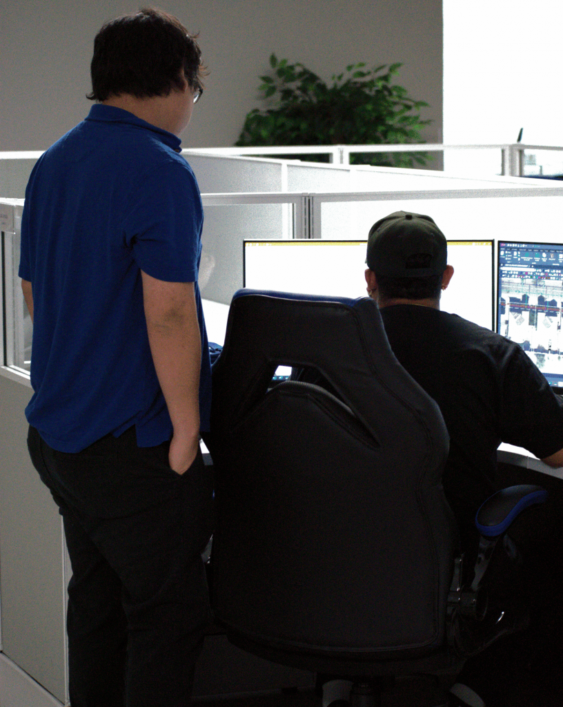 Two A Team Professional Associates employees collaborating at a dual-monitor workstation inside the company’s modern Tempe office. Photo by Jackson Kern.