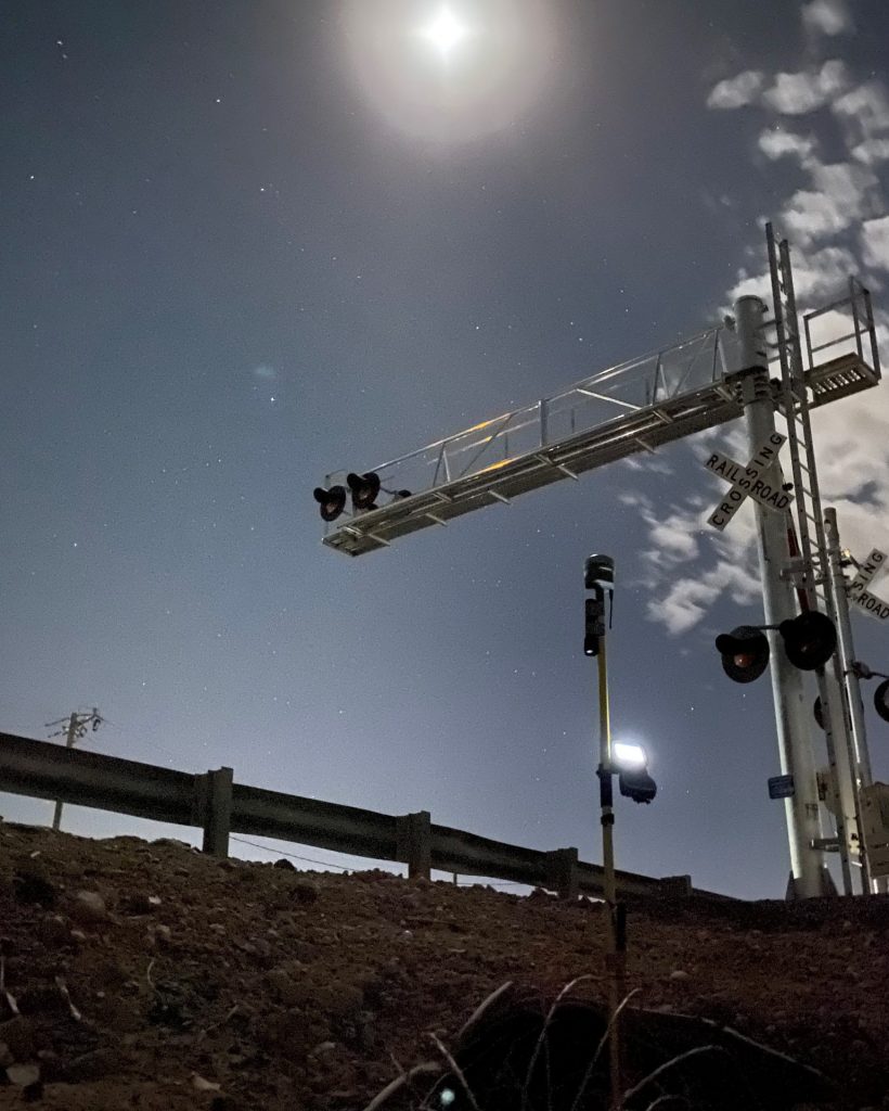 A Team Professional Associates survey equipment set up at a railroad crossing during a night surveying operation in Arizona. Photo by Nathan Robinson.