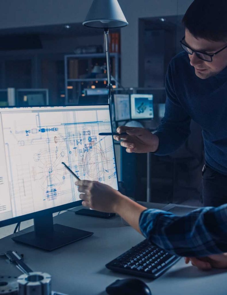 Engineers collaborating on utility design plans using CAD software in a modern office environment.